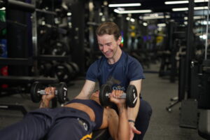 a personal trainer helping a gym client in beckenham